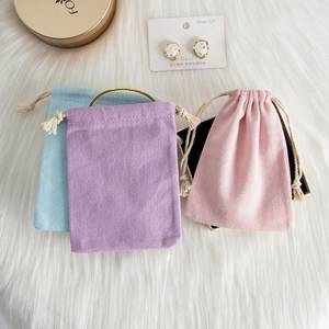 Detailed view of colorful drawstring jewelry pouches in blue purple and pink cotton fabric