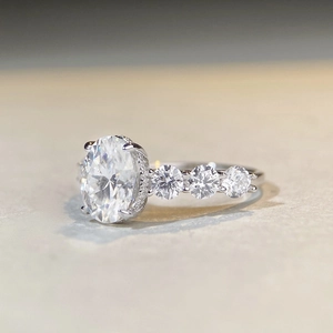 2ct oval cut moissanite silver ring with four-prong setting and side accent stones
