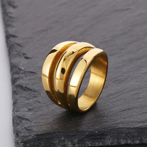 Macro view of gold triple-layered stainless steel ring on a textured slate background