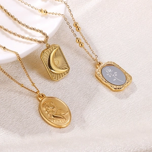 Vintage gold layered necklace set with moon and rose relief pendants on silk background