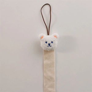 Close-up of cute plush bear wall hanging organizer with beige cotton woven ribbon