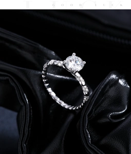Close-up of 1 carat moissanite ring with twisted silver band and four-prong setting