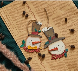 Detail of handcrafted wooden snowmen ornaments with Welcome and Snow signs for Christmas