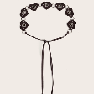 Detail of dark brown heart-shaped leather belt with star studs and silver rings