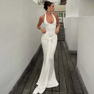 Detail of white halter neck maxi dress featuring waist knot and pleated draped fabric