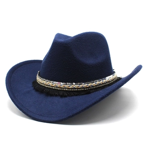 Macro detail of navy wool felt cowboy hat featuring ethnic tassels and woven bands