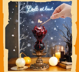 Gothic red rose candle held by hands on a vintage gold metal stand decoration