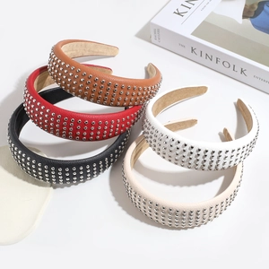 Detail view of five PU leather headbands with metal rivets in brown, red, black, and white
