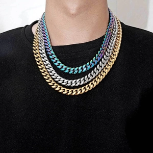 Close-up of gold, silver and rainbow Cuban link necklaces layered on a male model