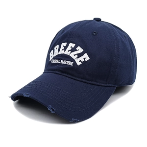 Dettaglio del cappellino blu navy effetto consumato con ricamo bianco e twill di cotone