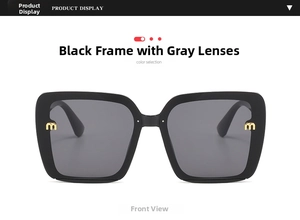 Detailed front view of black oversized square sunglasses with gold letter m and grey lenses