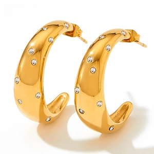Gros plan de boucles d'oreilles créoles dorées en C avec zircons ronds incrustés