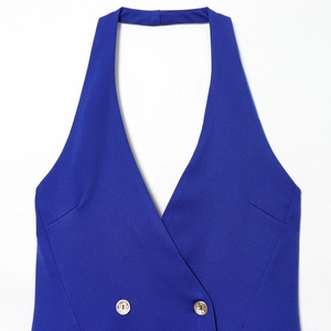 Gros plan sur une robe courte bleue à col licou avec boutons dorés croisés