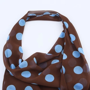 Detail of sheer brown chiffon scarf with light blue polka dot pattern and fine texture