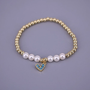 Golden beaded bracelet with white pearls and a blue zircon heart pendant for women