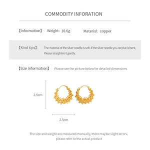 Vue détaillée des boucles d'oreilles créoles dorées 18k avec texture perlée et tiges argent