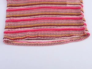 Detailed macro view of the colorful striped hollow crochet knit texture and finished hemline