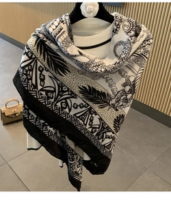 Detail of luxury vintage silk scarf with floral and chain patterns on white sweater