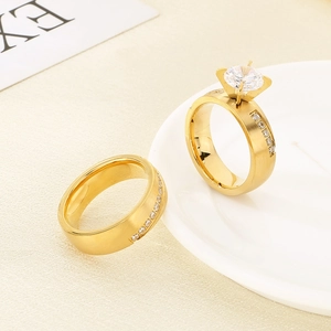 Close-up of gold solitaire diamond ring and sparkling pave band on a ceramic plate