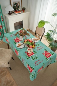 Detailed view of Christmas tablecloth with blue houses and festive tree patterns