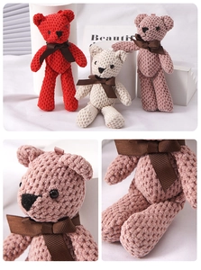 Detail of hand-knitted teddy bear plush keychain showing textures and ribbon bows