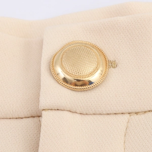 Elegant beige blazer suit waist detail with a textured gold button and smooth fabric