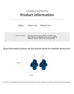 Detailed view of dark blue teardrop earrings with layered tassel scales and gold hooks
