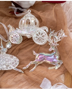 Detail of iridescent acrylic Christmas tree ornaments featuring pumpkin carriage and reindeer