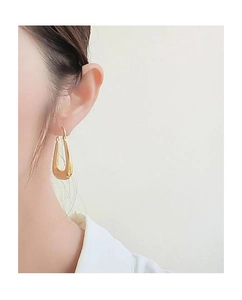 Close-up of a model wearing high-polished gold U-shaped hollow earrings with modern design