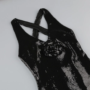Detail of black sequin dress featuring 3D rose decoration and cross shoulder straps