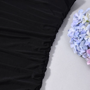 Close-up of black ruffled fabric with detailed knit texture and ruching craftsmanship