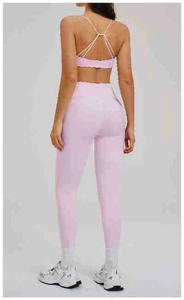 Vista posteriore del set yoga rosa chiaro con reggiseno incrociato e leggings a vita alta