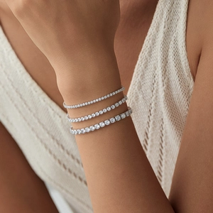 Three assorted sizes of S925 sterling silver tennis bracelets on a woman's wrist