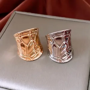 Irregular geometric hammered open rings in gold and silver finish on silk fabric