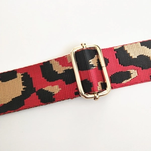 Close-up of leopard print nylon strap with adjustable gold metal buckle for bags