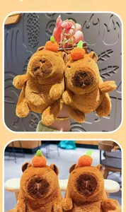 Detail of soft plush capybara keychain with orange head decor and golden metal clasp