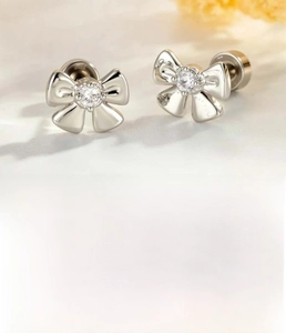 Macro shot of silver bow stud earrings with zircon center and steel screw back