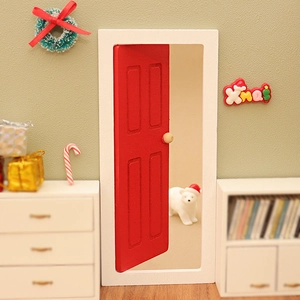 Miniature red dollhouse door with Christmas wreath and festive decor accessories