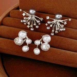 Macro detail of silver cluster earrings with white and grey pearls on velvet background