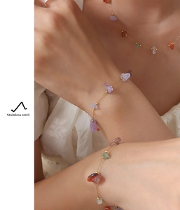 Detail of gold stainless steel necklace and bracelet with colorful natural stones