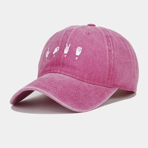 Close-up of white LOVE hand gesture embroidery on pink washed cotton baseball cap