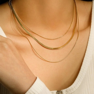 Close-up of triple-layered gold-plated stainless steel snake and delicate chain necklaces