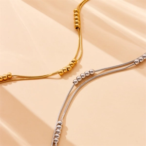 Double-layered stainless steel snake chain necklace set with polished beads in gold and silver