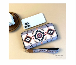 Detail of ethnic geometric pattern wallet with zipper closure and matching wristlet strap