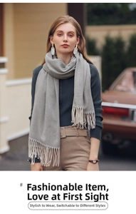 Gros plan sur une écharpe en tricot à chevrons gris et beige avec détails de franges douces