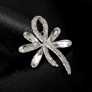 Macro detail of silver dragonfly brooch with sparkling crystals and rhinestones
