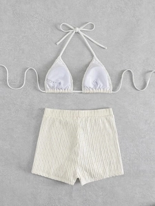 Close-up of off-white bikini set with vertical ribbed texture and elastic shorts