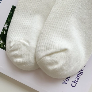 Detailed macro view of white cotton ribbed texture and flat seam stitching on socks