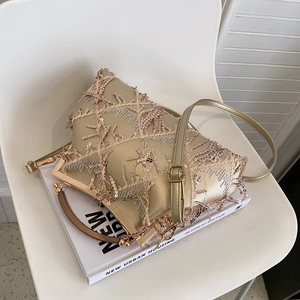 Detailed view of champagne gold evening bag with sequins tassels and embroidery texture