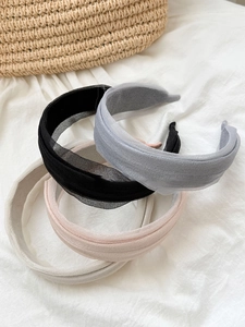 Flat lay of four elegant sheer gauze headbands in black, grey, beige, and pink colors
